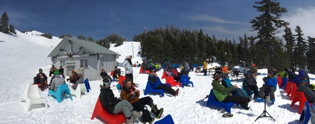 People sitting on chairs in the snow in the sun