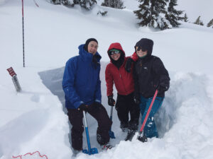3 people digging an avalanche pit together